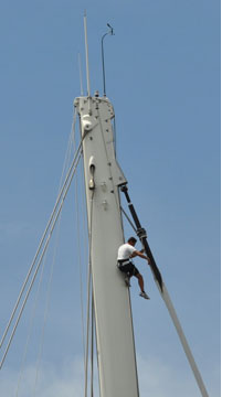 Photgraph of crew member working on ship's mast