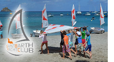 Children carrying a small boat at the St Barth Yacht Club